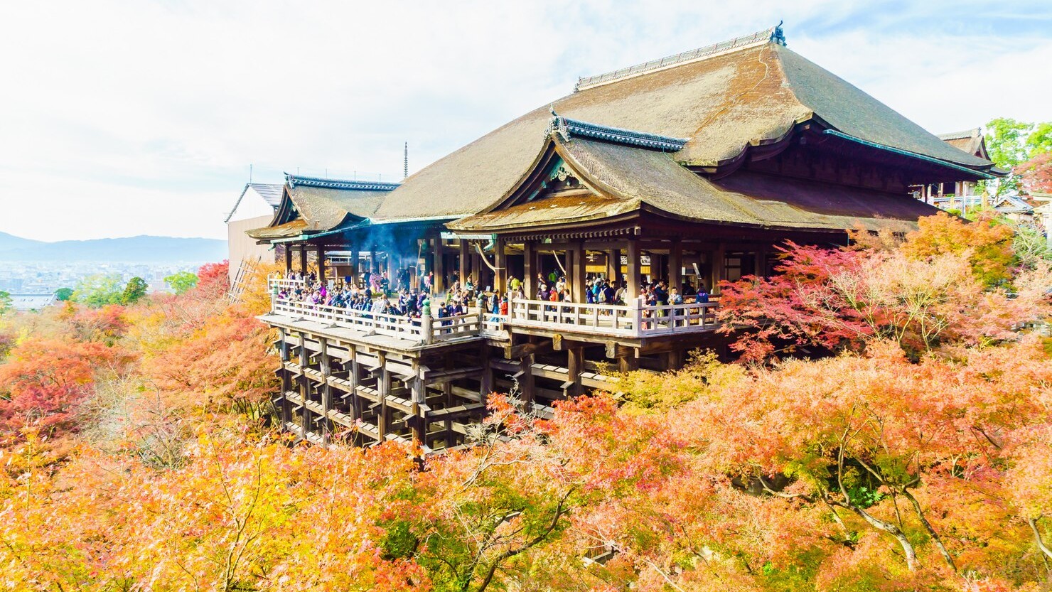 Kuil Kyoto dengan latar belakang daun momiji merah