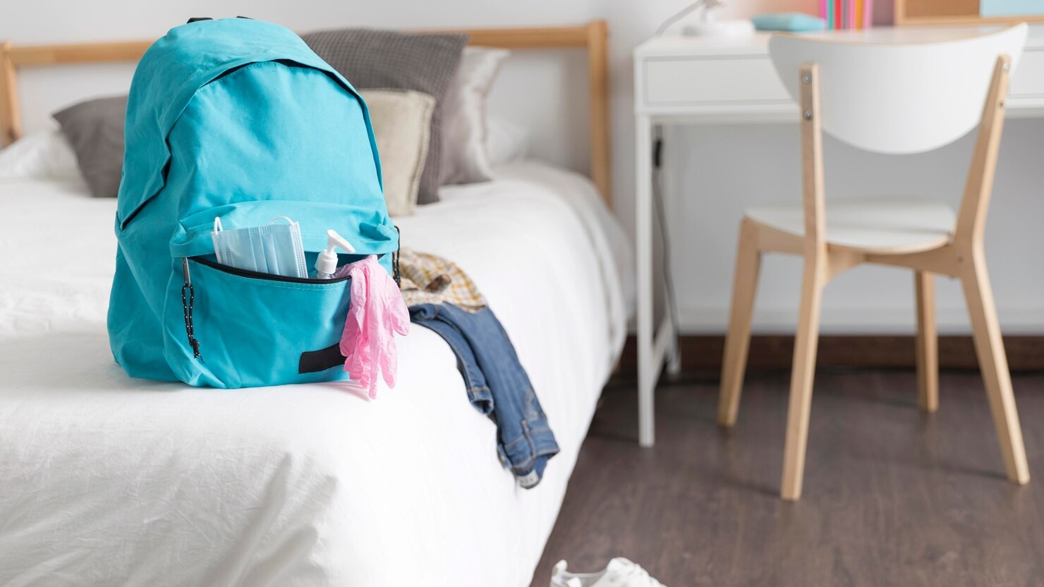 perlengkapan kecil tersusun di tempat tidur hotel